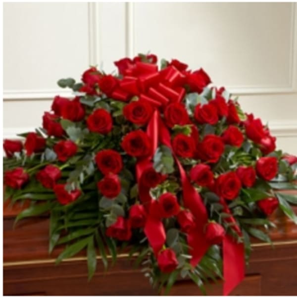 Large red rose casket spray with ribbon accents