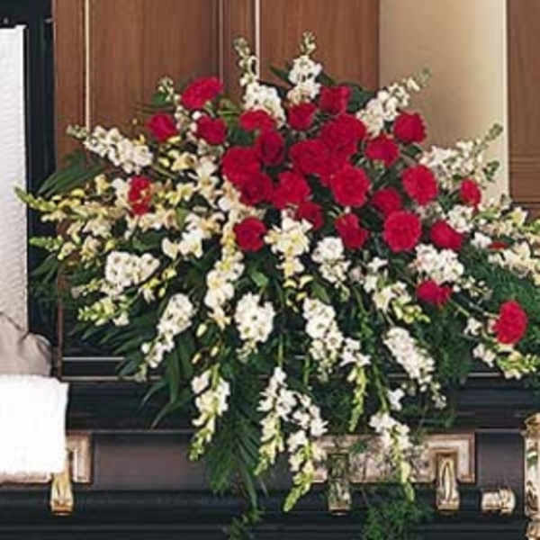 Large funeral spray of red and white flowers on a casket