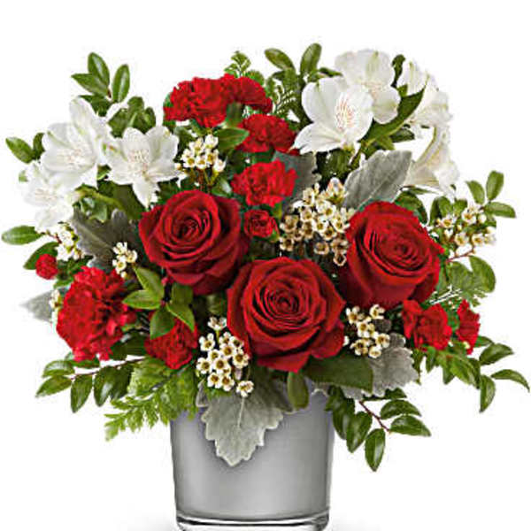 Red roses and white flowers arranged in a glass vase