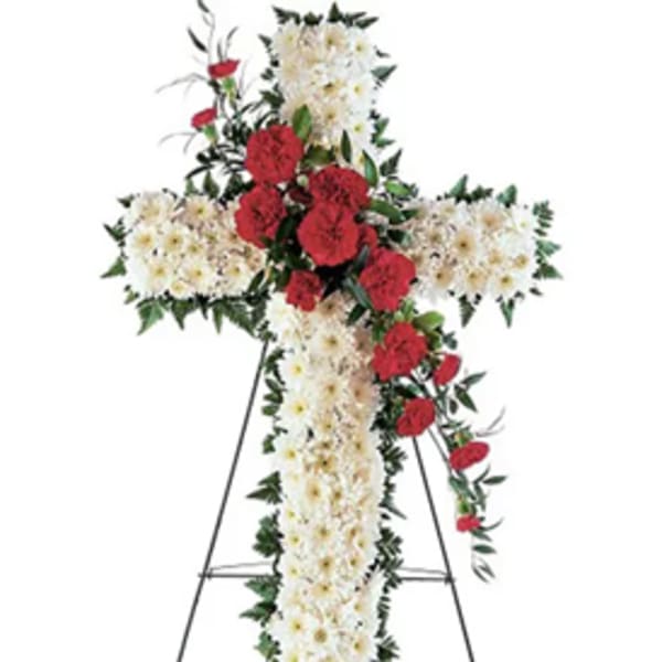 Standing floral cross with white and red flowers on an easel