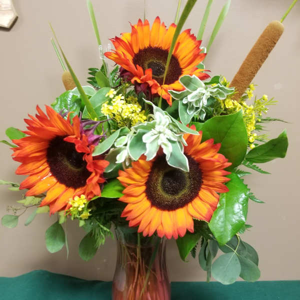 Bouquet of orange sunflowers in a glass vase