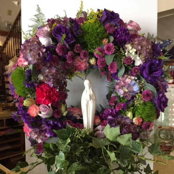 Purple floral wreath with a white statue in the center