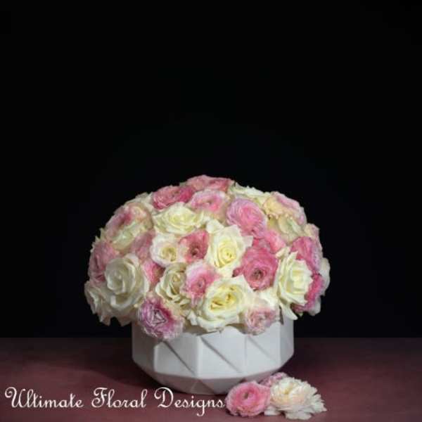 Round bouquet of pink and white roses in a white vase