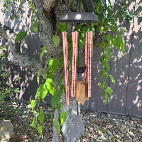 Copper wind chime hanging from a tree branch