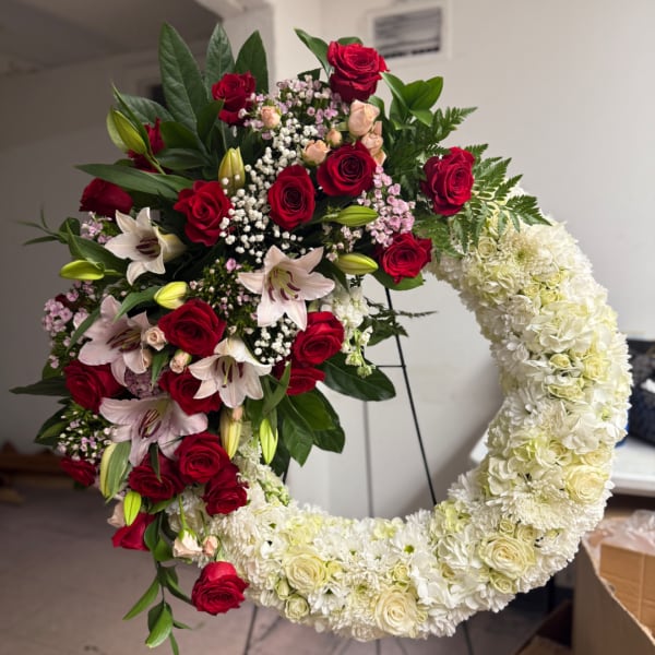 Heart-shaped floral wreath with red roses and white flowers