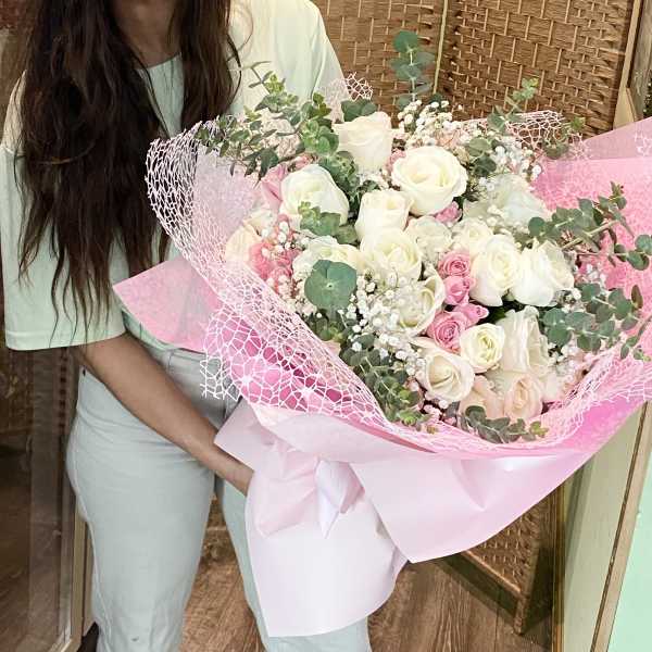 Large bouquet of white and pink roses wrapped in pink paper