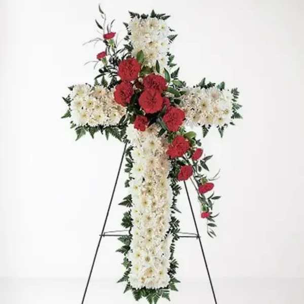 Cross-shaped floral standing spray with white and red flowers on an easel