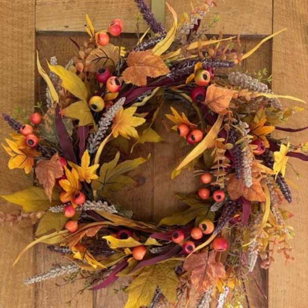 Autumn wreath with berries and mixed foliage on a wooden door
