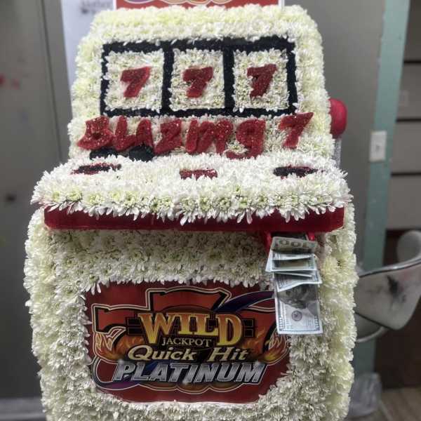 Floral display shaped like a slot machine with cash attached