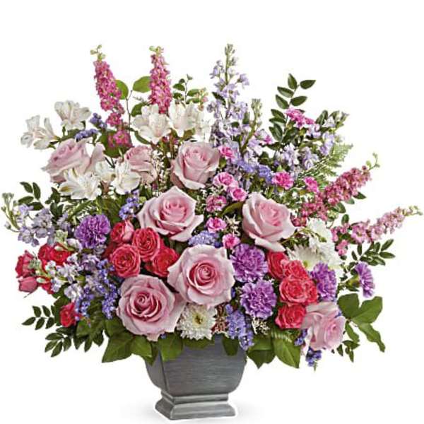 Mixed pink and purple flower arrangement in a gray urn vase