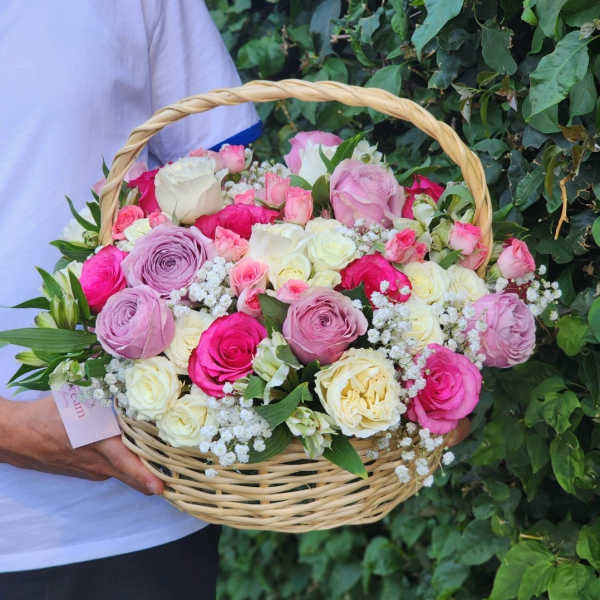 Basket of pink, white, and lavender roses with baby's breath