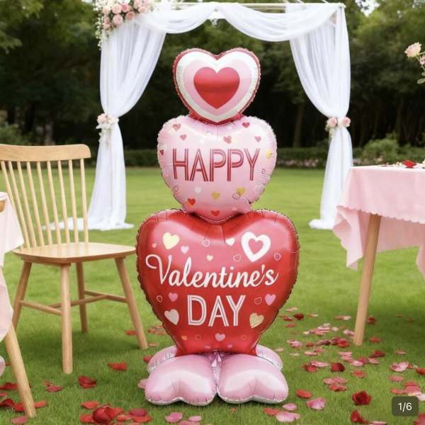 Heart-shaped Valentine's Day balloons stacked outdoors with white drapery