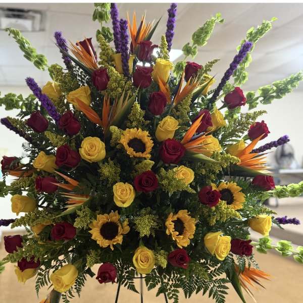 Large mixed bouquet with red and yellow roses, sunflowers, and purple spikes