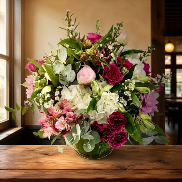 Mixed bouquet of pink, white, and magenta flowers in a glass vase