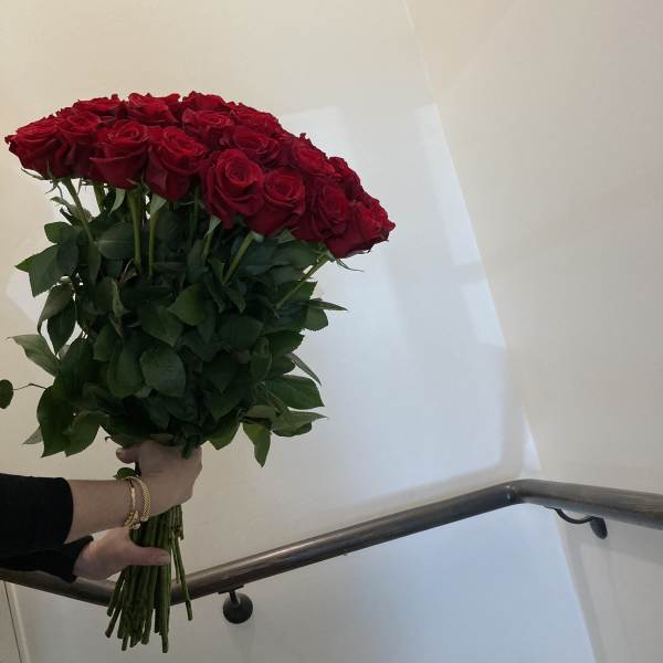 Large bouquet of red roses held by hand