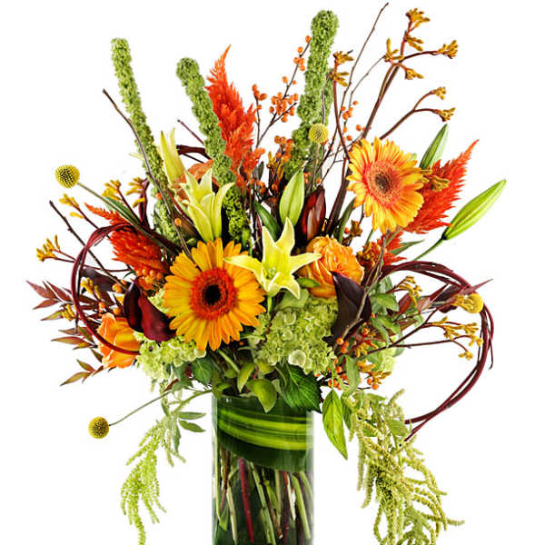 Tall autumn bouquet with orange gerbera daisies and lilies in a glass vase