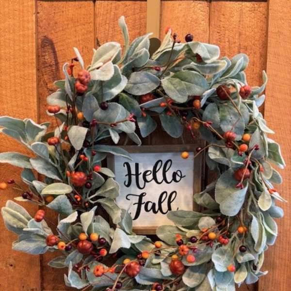 Fall wreath with blue-green leaves and berry accents around a Hello Fall sign