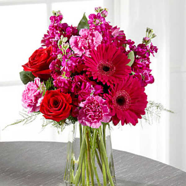Pink and red mixed bouquet in a clear glass vase