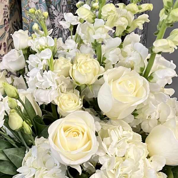 White roses and hydrangeas with pale green stock in a bouquet