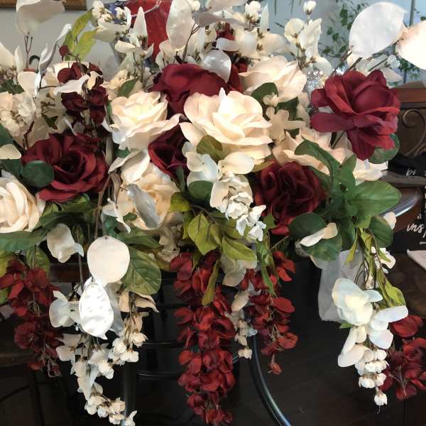 Large arrangement of red and white roses with cascading white orchids