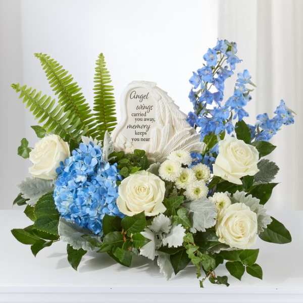 Blue and white floral sympathy arrangement with a memorial stone