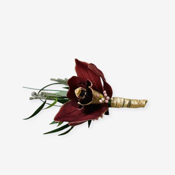 Dark red orchid boutonniere with gold-wrapped stem and greenery