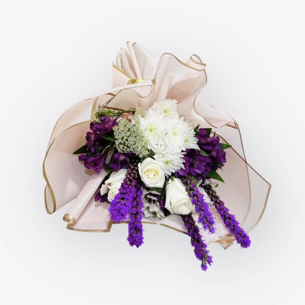 Bouquet of white and purple flowers wrapped in pale pink paper