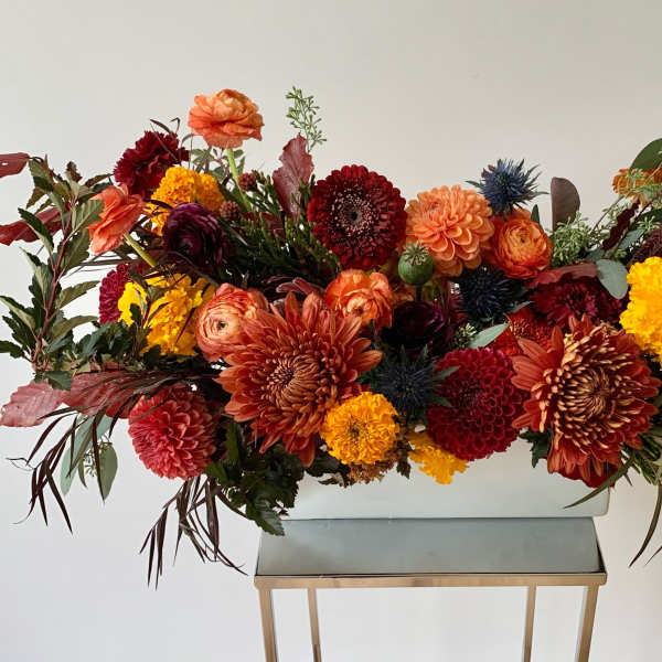 Large autumn flower arrangement in a white rectangular container