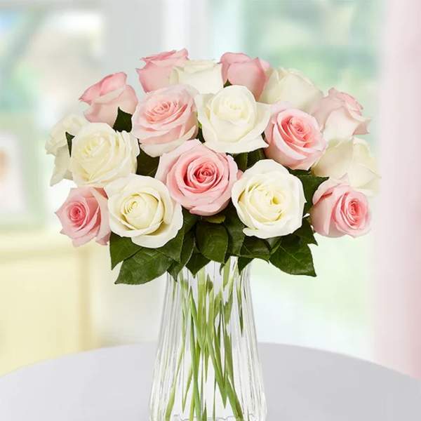 Bouquet of pink and white roses in a clear glass vase