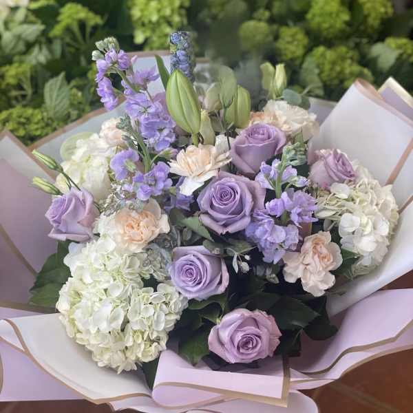Bouquet of lavender roses, white hydrangeas, and pale peach flowers