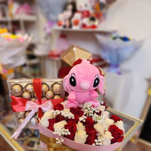 Pink plush toy with a rose and chocolate gift box arrangement