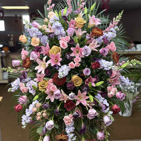 Large standing floral spray with pink, lavender, and yellow blooms
