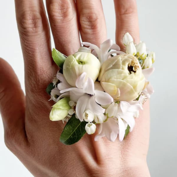 Small floral ring with cream and white blooms on a hand