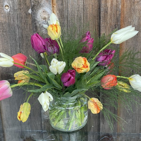 Mixed tulips arranged in a clear glass vase