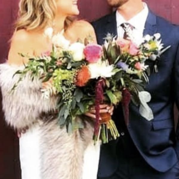 Bride and groom holding a colorful wedding bouquet