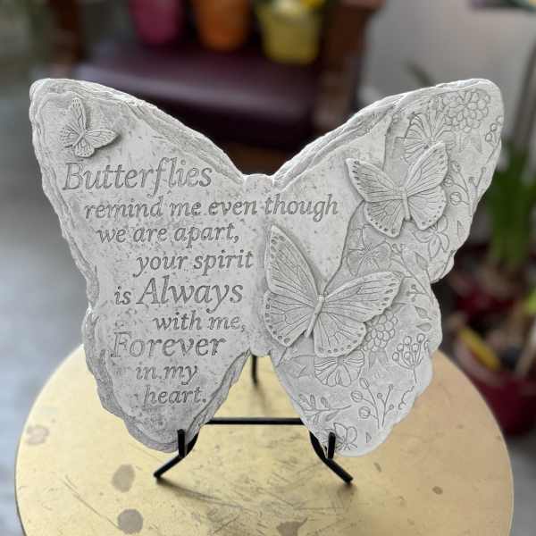 Butterfly-shaped memorial plaque with an engraved quote on a stand