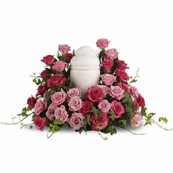 Pink and magenta roses arranged around a white urn