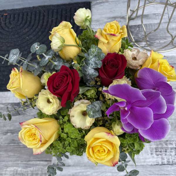 Bouquet of yellow and red roses with purple orchids