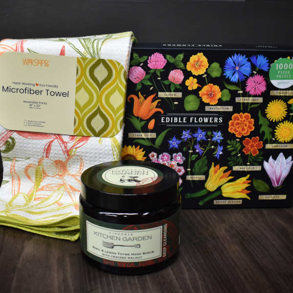 Gift set with a floral kitchen towel, edible flowers puzzle, and hand scrub jar