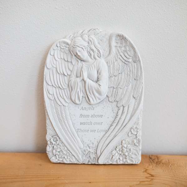 White angel memorial plaque with engraved text and flowers