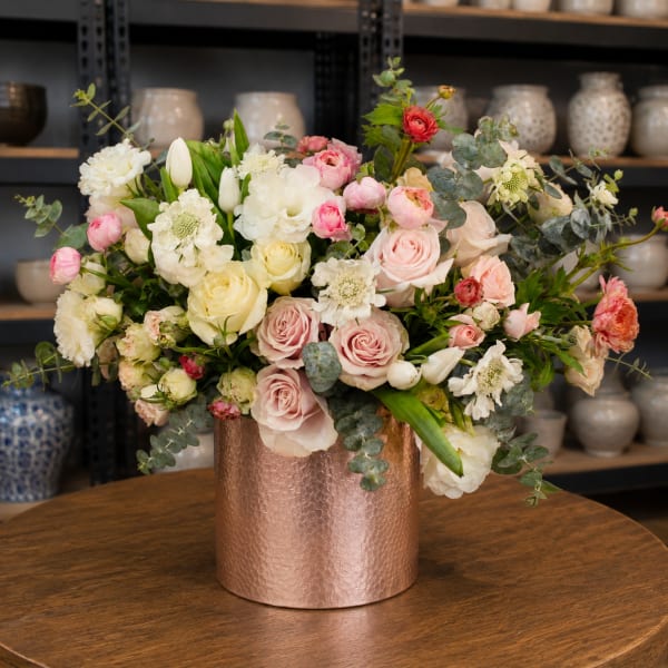 Mixed bouquet of pink, white, and cream flowers in a copper vase