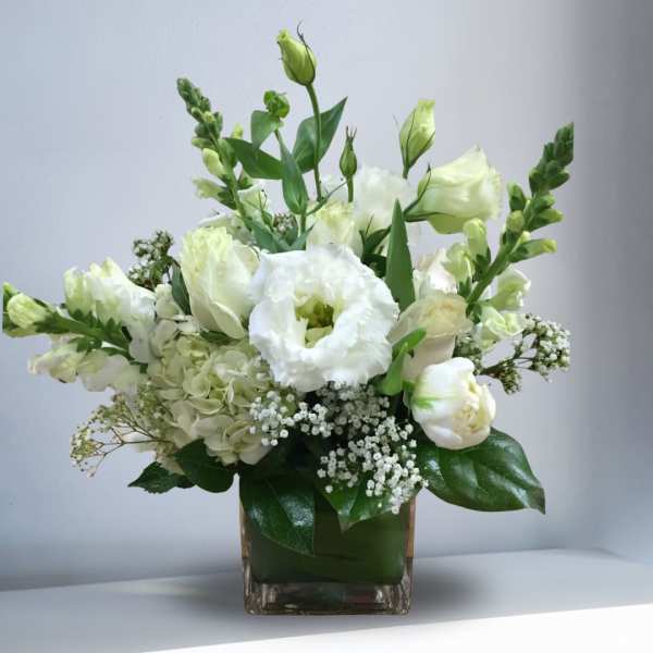 White flowers arranged in a square glass vase