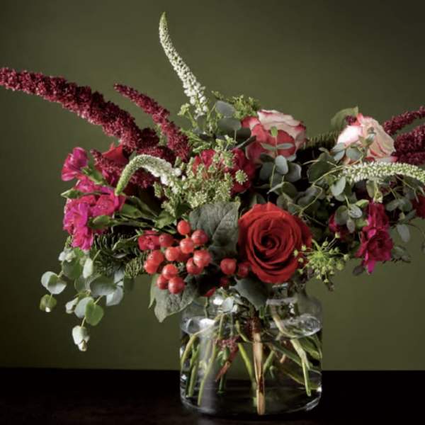 Red and pink floral arrangement in a clear glass vase