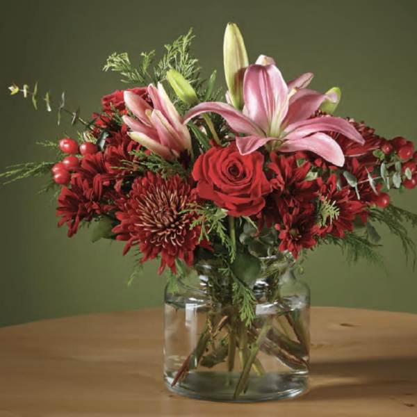 Red and pink floral arrangement in a clear glass vase