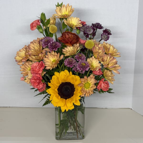 Mixed bouquet with a sunflower in a clear glass vase