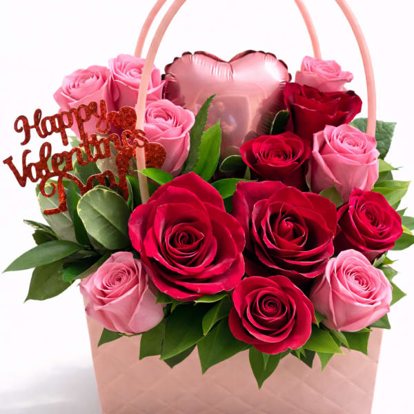 Pink and red roses in a gift basket with a heart balloon