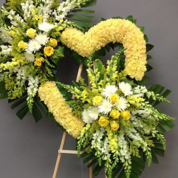 Two yellow and white floral heart wreaths on easels