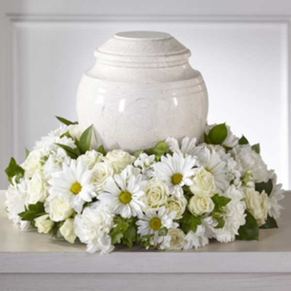 White floral arrangement around a white urn