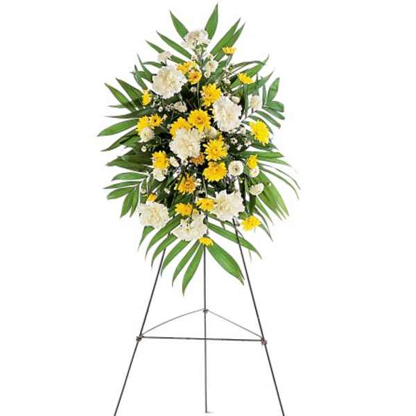 Standing floral spray with yellow and white flowers on an easel