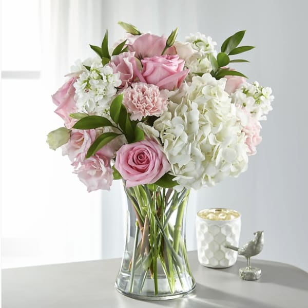 Pink roses and white hydrangeas in a clear glass vase